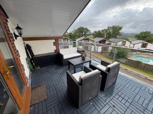 a patio with chairs and a table on a balcony at Between the Moors Hideaway in High Bickington