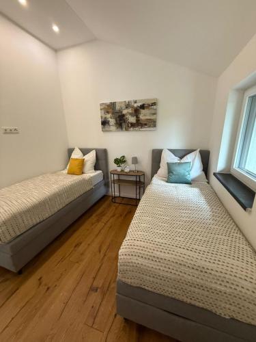 a bedroom with two beds and a window at Stylische Ferienwohnung in Salzburg