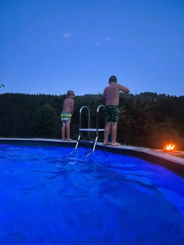 two men standing on the edge of a swimming pool at Time out near Lake of Thun & Emmental region in Fahrni