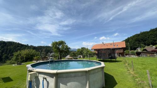 a large swimming pool in a field with a house at Time out near Lake of Thun & Emmental region in Fahrni