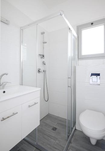 a white bathroom with a shower and a toilet at 4BDR apt with jacuzzi in the heart of the city in Qiryat Ata