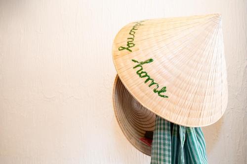 a straw hat is hanging on a wall at Homestay Thùy Dương 1 in Cai Be
