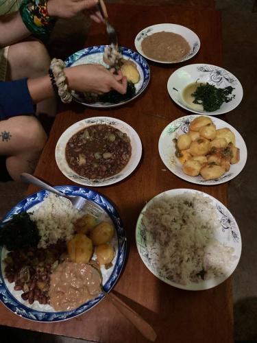 a wooden table with plates of food on it at Sipi Backpackers in Kapchorwa