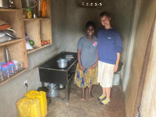 a man and a woman standing in a small kitchen at Sipi Backpackers in Kapchorwa