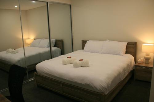 a bedroom with two beds with towels on them at Stylish 1Bedroom Apartment with Study and Parking Near Sydney Airport in Sydney