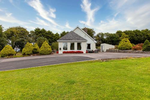 a white house with a driveway and a grass field at Fernfeild in Old Twopothouse Cross Roads