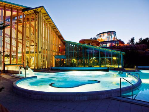 une grande piscine en face d'un bâtiment dans l'établissement WONNEMAR Resort-Hotel, à Wismar