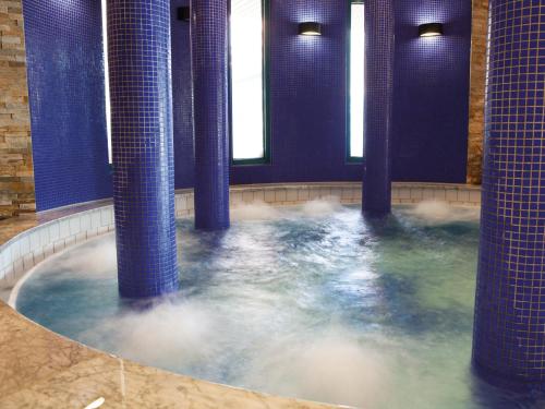 a jacuzzi tub with blue columns in a building at WONNEMAR Resort-Hotel in Wismar