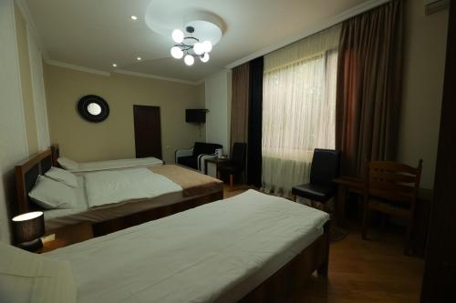 a hotel room with two beds and a window at Hotel Harmony in Kutaisi