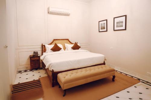 a bedroom with a bed and a bench in it at Victoria Mansion - A Signature Collection by HST Hotels in Udaipur