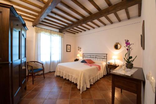 - une chambre avec un lit et une grande fenêtre dans l'établissement Casa Lari, à San Gimignano