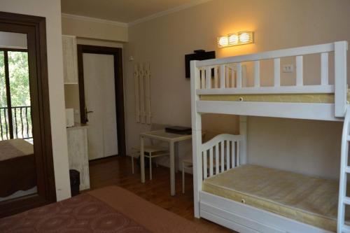 a bedroom with two bunk beds and a desk at Bakuriani Mgzavrebi in Bakuriani