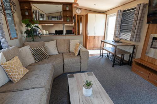 a living room with a couch and a table at Caravan Hire Mersea Island - EOEPS in East Mersea
