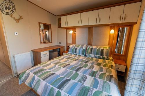 a bedroom with a bed and a desk in it at Caravan Hire Mersea Island - EOEPS in East Mersea