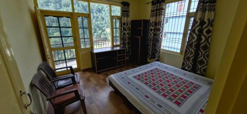 a bedroom with a bed in a room with windows at Nitin Home Stay in Rewalsar