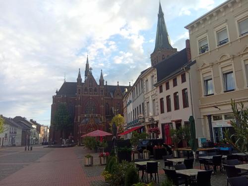 a city street with tables and chairs and a building at Altstadtnahe Wohnung & Balkon & ruhig in Viersen