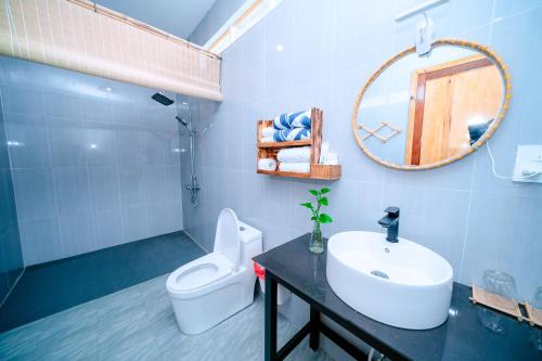a bathroom with a sink and a toilet and a mirror at Homestay Thùy Dương 1 in Cai Be