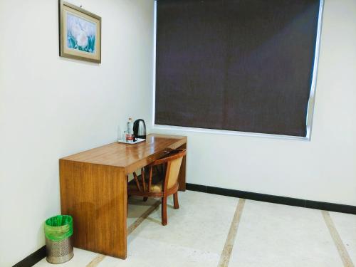 a wooden desk in a room with a large screen at Athasri Hotel Infantry Road in Bengaluru