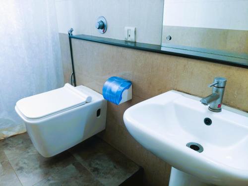 a bathroom with a sink and a toilet and a mirror at Athasri Hotel Infantry Road in Bengaluru