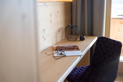 a desk with a book and glasses and a book at Alpenkönig in Zell am Ziller