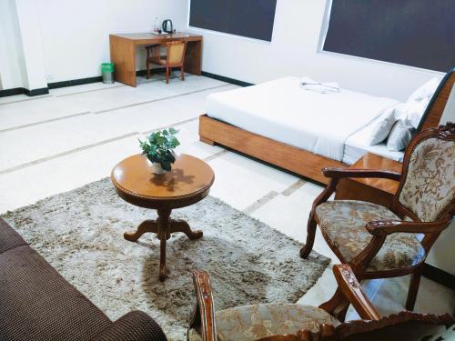 a living room with a coffee table and a bed at Athasri Hotel Infantry Road in Bengaluru