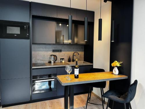 a kitchen with a table with a bottle of wine at Smarty Choice Living with Netflix - Kubánské náměstí in Prague