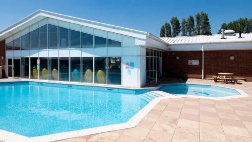 a swimming pool in front of a building at Caravan Hire Mersea Island - EOEPS in East Mersea