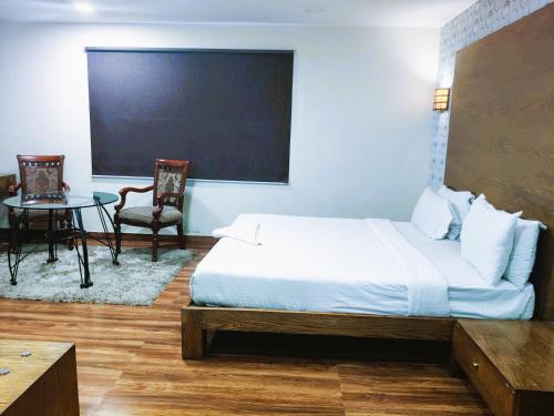 a bedroom with a bed and a table and a chalkboard at Athasri Hotel Infantry Road in Bengaluru