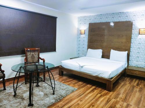 a bedroom with a bed and a table and a chalkboard at Athasri Hotel Infantry Road in Bengaluru