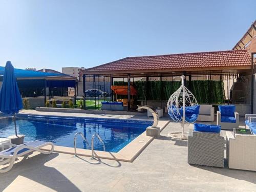 a swimming pool with chairs and a gazebo at Oriana - your sanctuary escape in Amman