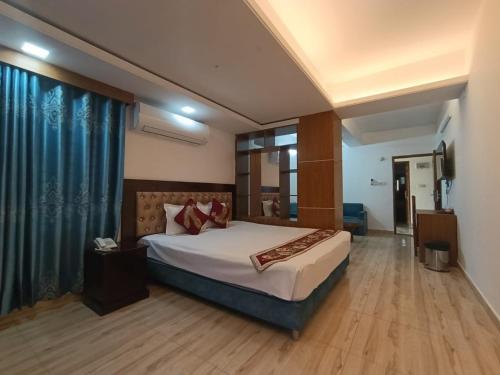 a bedroom with a bed and a blue curtain at Hotel D Palace in Dhaka