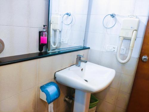 a bathroom with a sink and a mirror at Athasri Hotel Infantry Road in Bengaluru