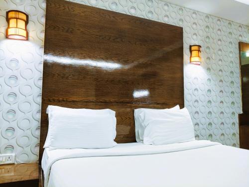 two beds in a room with two white pillows at Athasri Hotel Infantry Road in Bengaluru