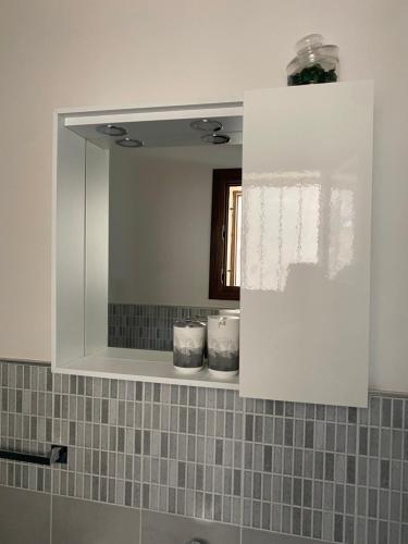 a bathroom with a mirror and a sink at Xenia Rooms in Salemi