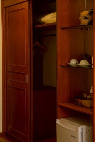 a kitchen with a cupboard and a refrigerator at CS Pattani Hotel in Ban Ru Sa Mi Lae