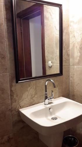 a bathroom with a sink and a mirror at Sibel Hotel in Antalya