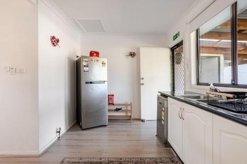 a kitchen with a stainless steel refrigerator in a room at All in One Home Work, Relax & Weekend Escape in Bomaderry