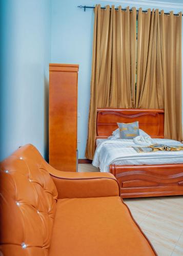 a bedroom with a bed and a leather couch at Advem Villa in Dodoma