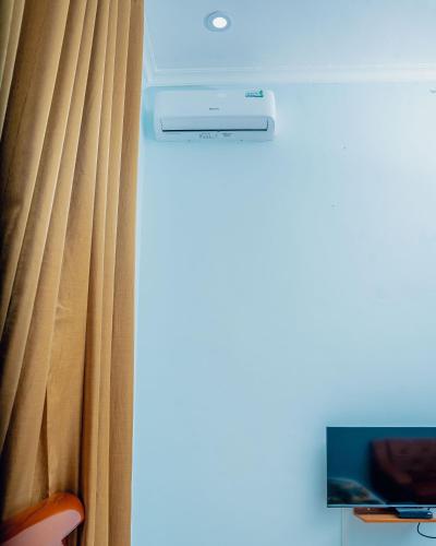 a room with a curtain and a tv at Advem Villa in Dodoma