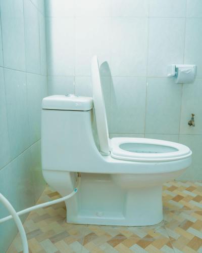 a bathroom with a toilet with the lid up at Advem Villa in Dodoma
