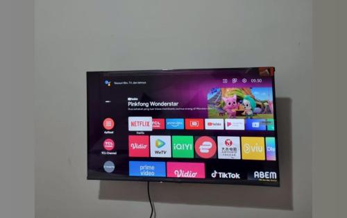 a flat screen tv hanging on a wall at RBE Hotel Kuta 3- 5 Min to Airport&Beach by Micky Studio in Ngurah Rai International Airport