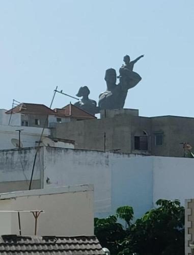 un edificio con una statua in cima di Joyce a Dakar