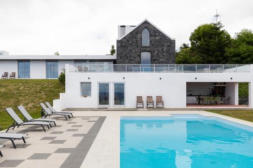 a house with a swimming pool in front of it at Grande Mar Villa in Ponta Garça