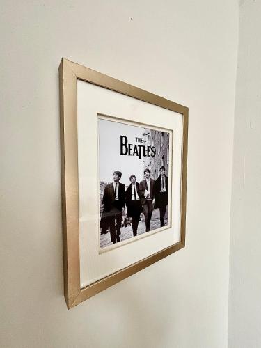 a picture of the beatles hanging on a wall at The Liverpool Escape - 5 min walk to LFC Stadium, Sleeps 8, newly renovated entire home in Liverpool