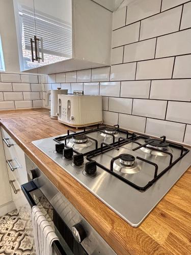 a kitchen with a stove top in a kitchen at The Liverpool Escape - 5 min walk to LFC Stadium, Sleeps 8, newly renovated entire home in Liverpool