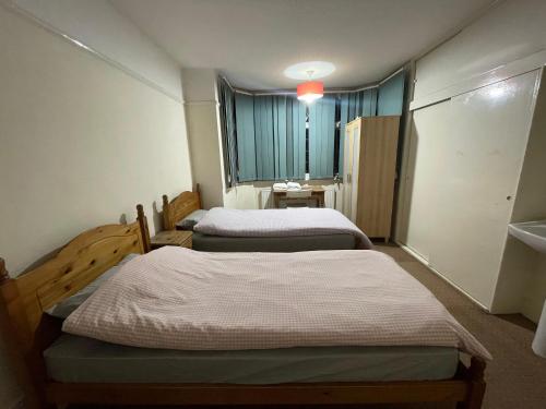 a room with two beds and a window at Budget Stay In Luton 02 04 in Luton