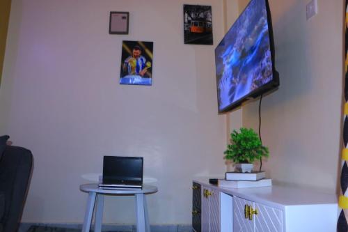 a room with a table and a tv on a wall at Cari comfy suite in Juja