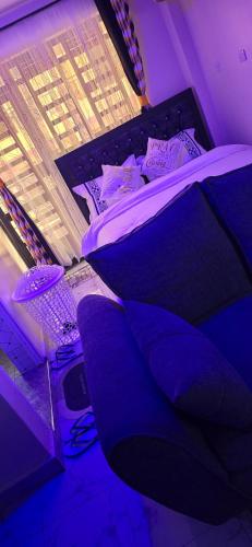 a bed in a room with purple lighting at Cari comfy suite in Juja