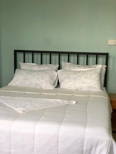 a large bed with white sheets and pillows at Mayian Luxury Lodge in Usa River