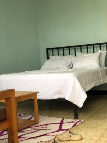 a bed with white sheets and pillows in a bedroom at Mayian Luxury Lodge in Usa River